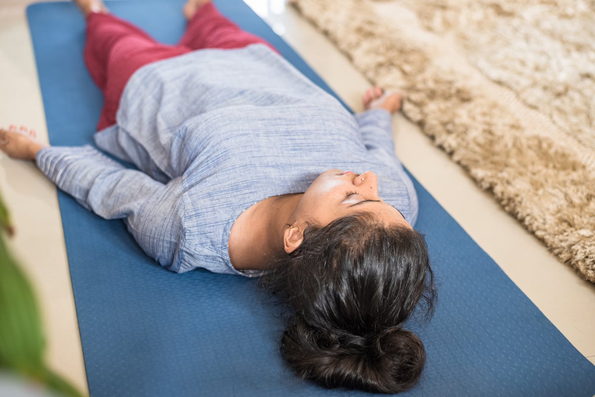 Woman Lying on Yoga Mat